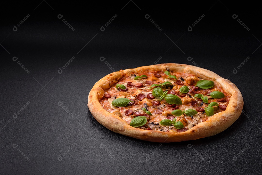 Deliciosa pizza com salsicha, queijo, tomate, sal, especiarias e ervas sobre um fundo escuro de concreto