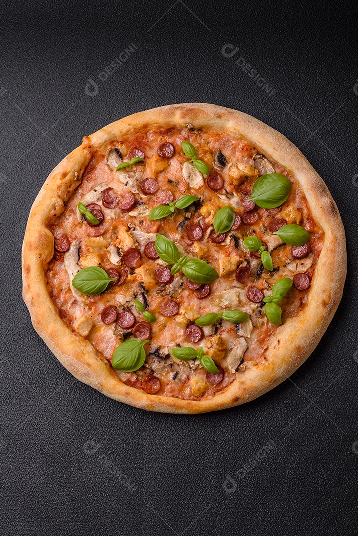 Deliciosa pizza com salsicha, queijo, tomate, sal, especiarias e ervas sobre um fundo escuro de concreto