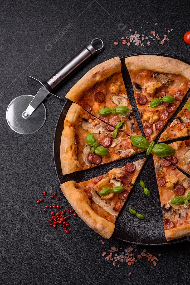 Deliciosa pizza com salsicha, queijo, tomate, sal, especiarias e ervas sobre um fundo escuro de concreto