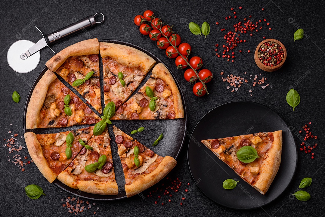 Deliciosa pizza com salsicha, queijo, tomate, sal, especiarias e ervas sobre um fundo escuro de concreto