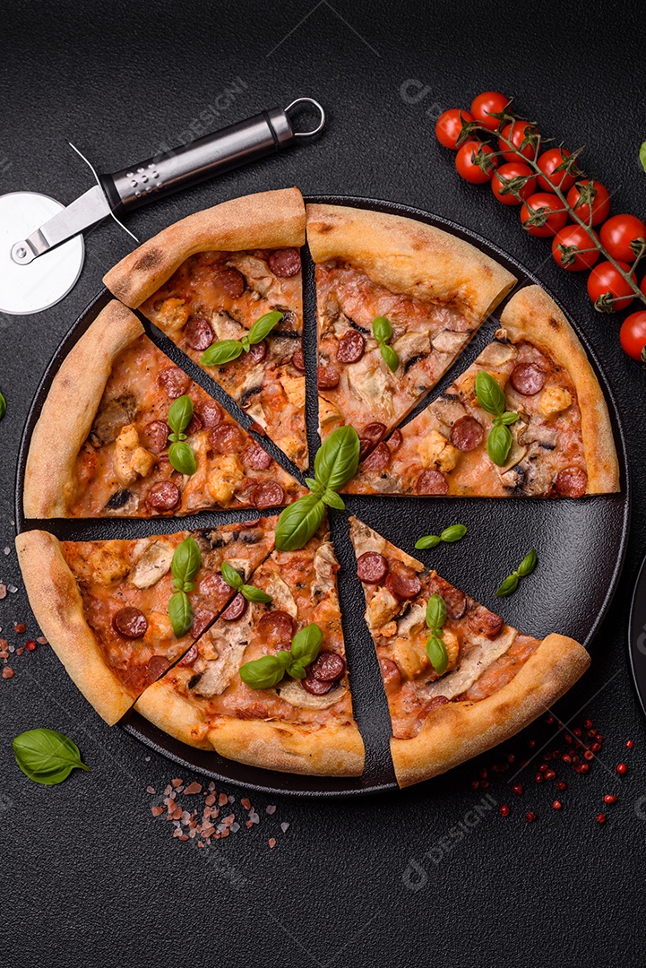 Deliciosa pizza com salsicha, queijo, tomate, sal, especiarias e ervas sobre um fundo escuro de concreto