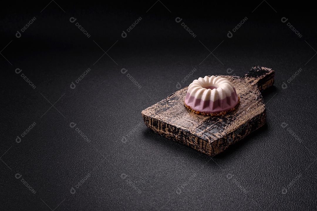 Delicioso cheesecake redondo rosa e branco, sem lactose, sem açúcar, nutrição saudável, sobre um fundo escuro de concreto