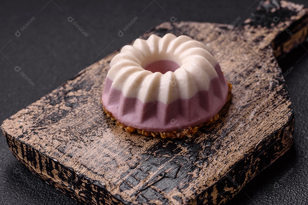 Delicioso cheesecake redondo rosa e branco, sem lactose, sem açúcar, nutrição saudável, sobre um fundo escuro de concreto