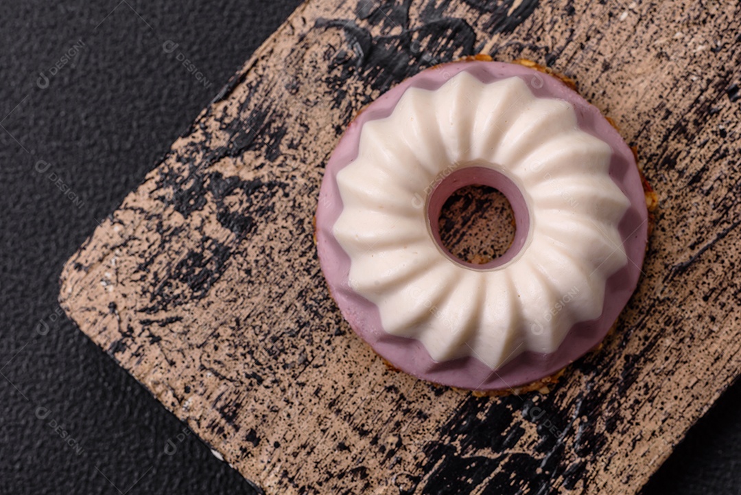 Delicioso cheesecake redondo rosa e branco, sem lactose, sem açúcar, nutrição saudável, sobre um fundo escuro de concreto