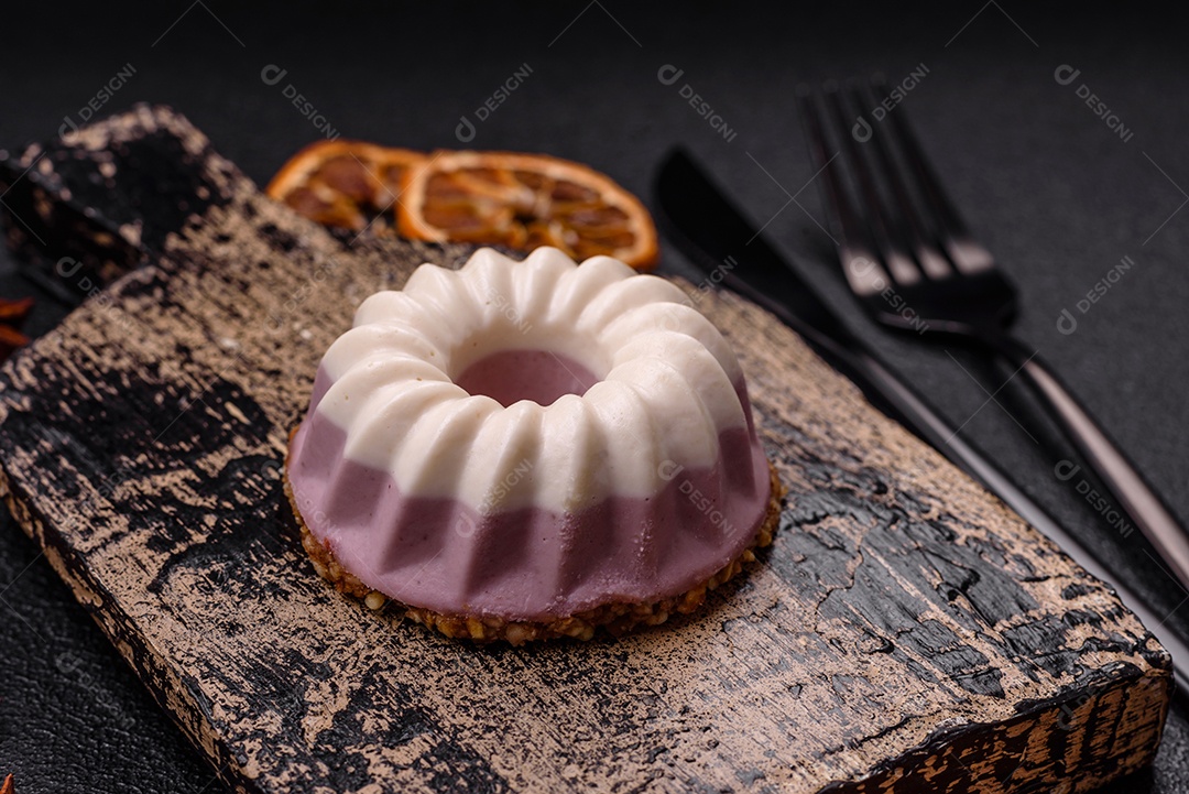 Delicioso cheesecake redondo rosa e branco, sem lactose, sem açúcar, nutrição saudável, sobre um fundo escuro de concreto