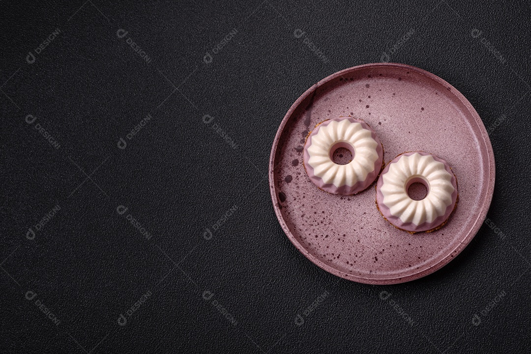 Delicioso cheesecake redondo rosa e branco, sem lactose, sem açúcar, nutrição saudável, sobre um fundo escuro de concreto