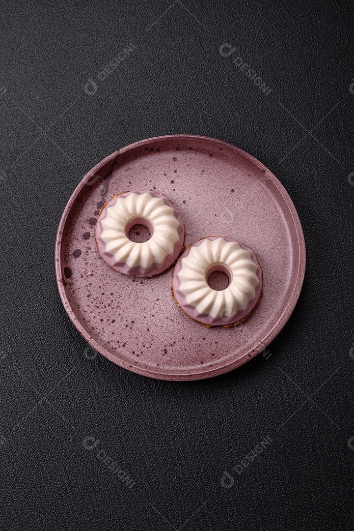 Delicioso cheesecake redondo rosa e branco, sem lactose, sem açúcar, nutrição saudável, sobre um fundo escuro de concreto