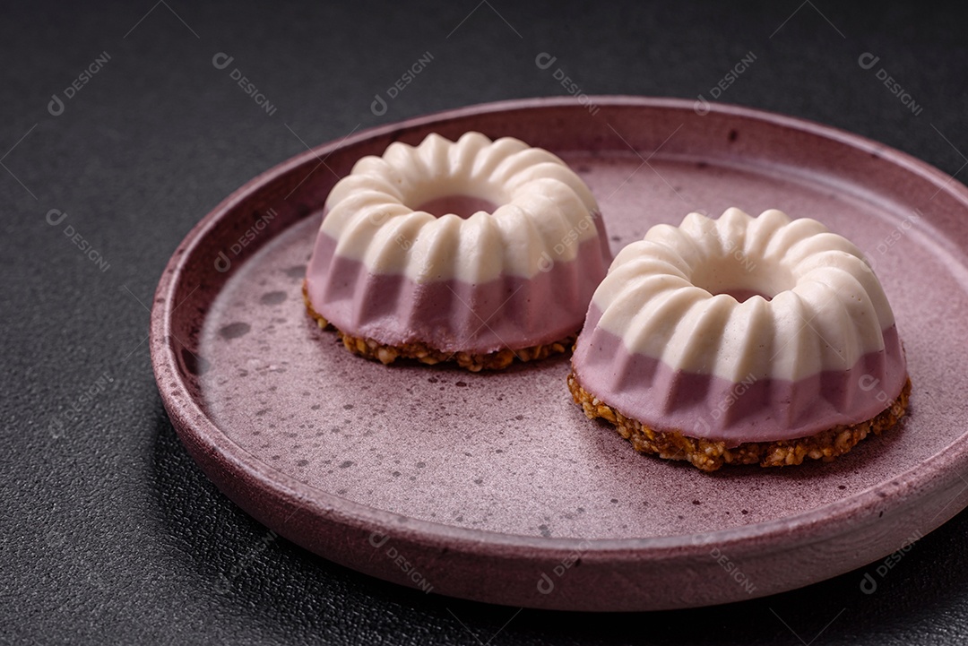 Delicioso cheesecake redondo rosa e branco, sem lactose, sem açúcar, nutrição saudável, sobre um fundo escuro de concreto