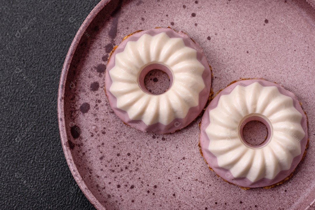 Delicioso cheesecake redondo rosa e branco, sem lactose, sem açúcar, nutrição saudável, sobre um fundo escuro de concreto