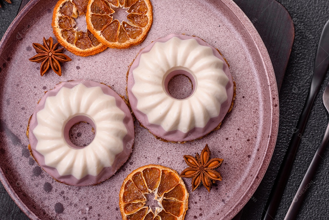 Delicioso cheesecake redondo rosa e branco, sem lactose, sem açúcar, nutrição saudável, sobre um fundo escuro de concreto