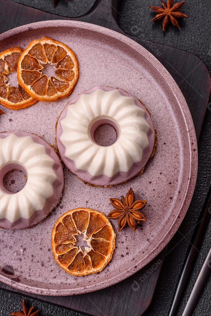 Delicioso cheesecake redondo rosa e branco, sem lactose, sem açúcar, nutrição saudável, sobre um fundo escuro de concreto