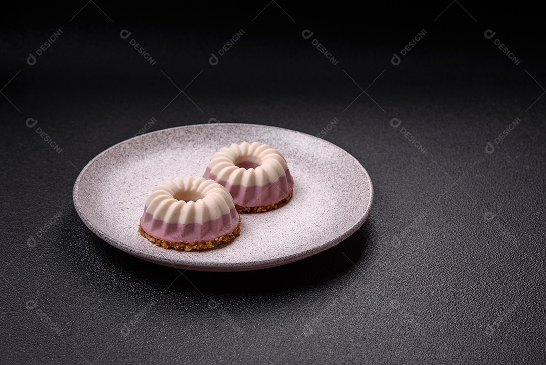 Delicioso cheesecake redondo rosa e branco, sem lactose, sem açúcar, nutrição saudável, sobre um fundo escuro de concreto