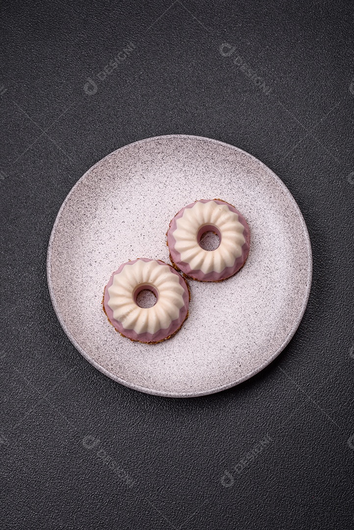 Delicioso cheesecake redondo rosa e branco, sem lactose, sem açúcar, nutrição saudável, sobre um fundo escuro de concreto