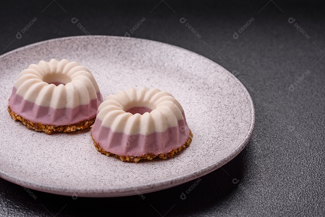 Delicioso cheesecake redondo rosa e branco, sem lactose, sem açúcar, nutrição saudável, sobre um fundo escuro de concreto