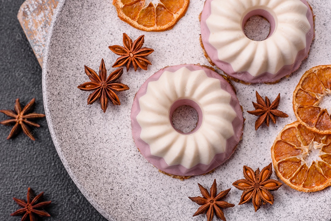 Delicioso cheesecake redondo rosa e branco, sem lactose, sem açúcar, nutrição saudável, sobre um fundo escuro de concreto