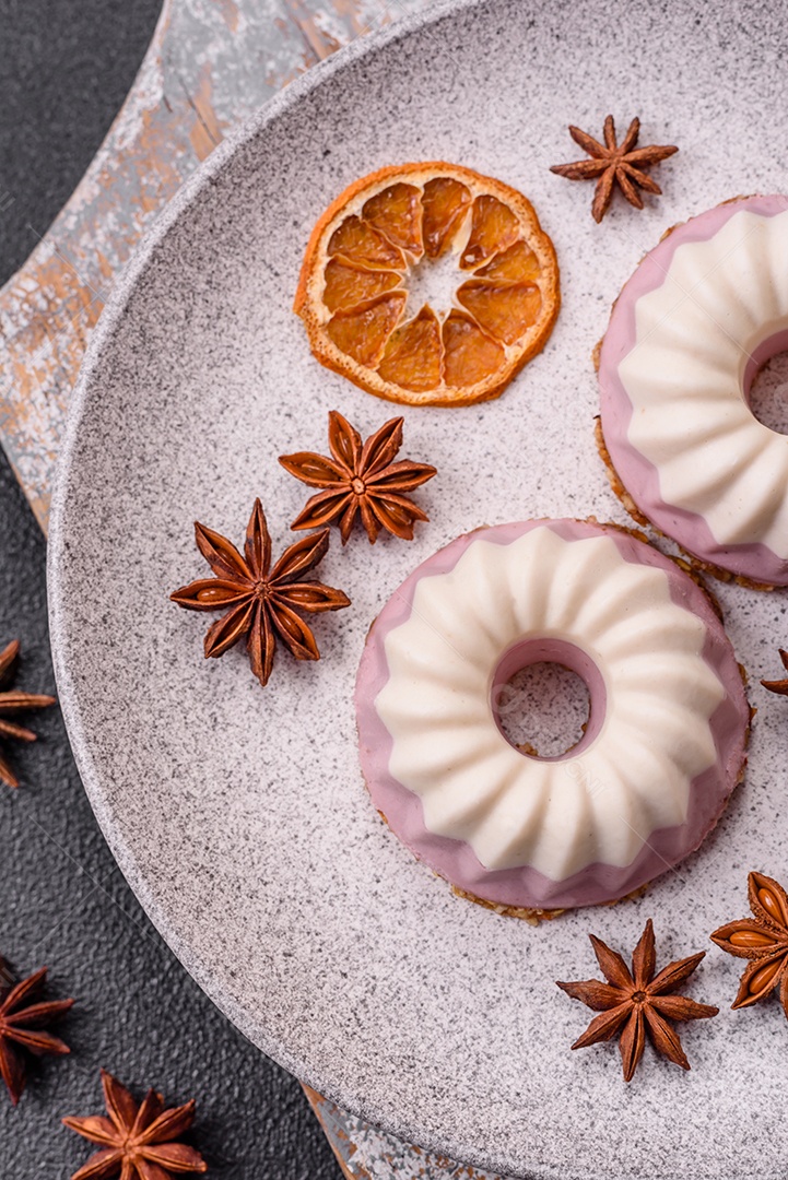 Delicioso cheesecake redondo rosa e branco, sem lactose, sem açúcar, nutrição saudável, sobre um fundo escuro de concreto