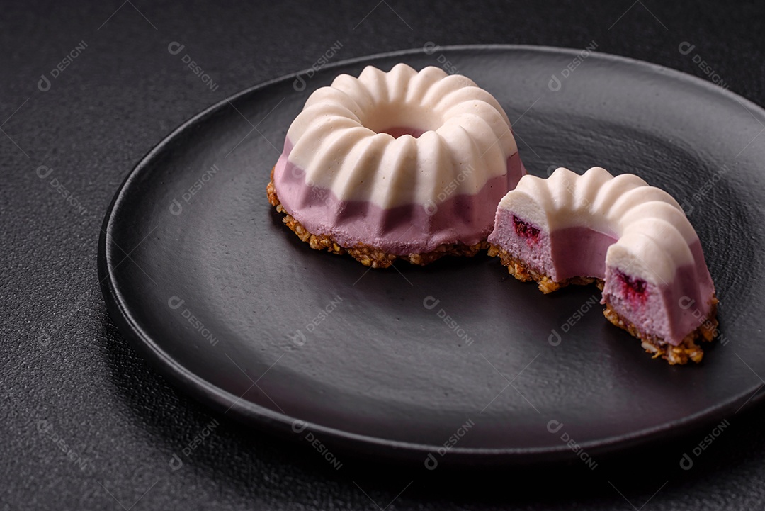 Delicioso cheesecake redondo rosa e branco, sem lactose, sem açúcar, nutrição saudável, sobre um fundo escuro de concreto