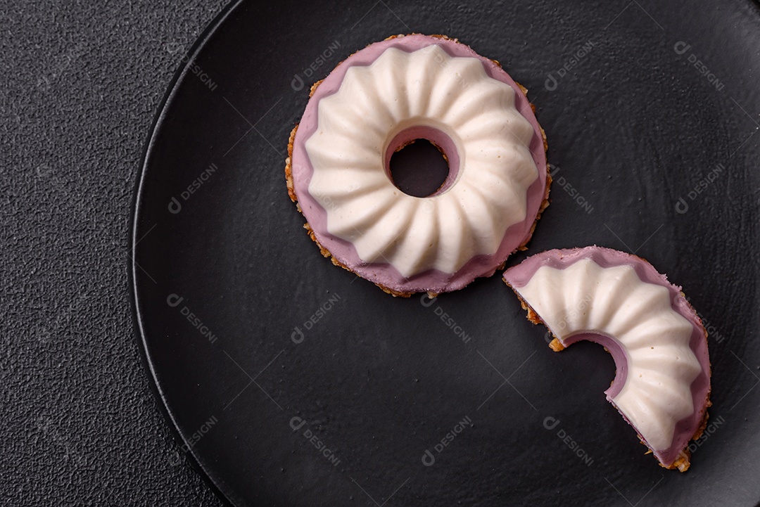 Delicioso cheesecake redondo rosa e branco, sem lactose, sem açúcar, nutrição saudável, sobre um fundo escuro de concreto