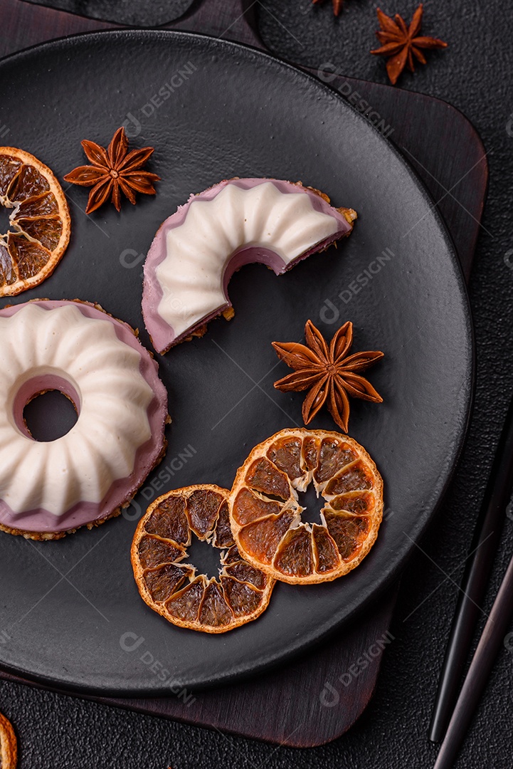 Delicioso cheesecake redondo rosa e branco, sem lactose, sem açúcar, nutrição saudável, sobre um fundo escuro de concreto