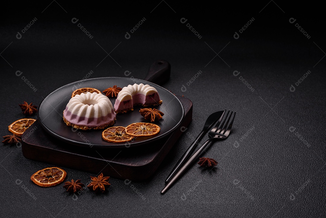 Delicioso cheesecake redondo rosa e branco, sem lactose, sem açúcar, nutrição saudável, sobre um fundo escuro de concreto