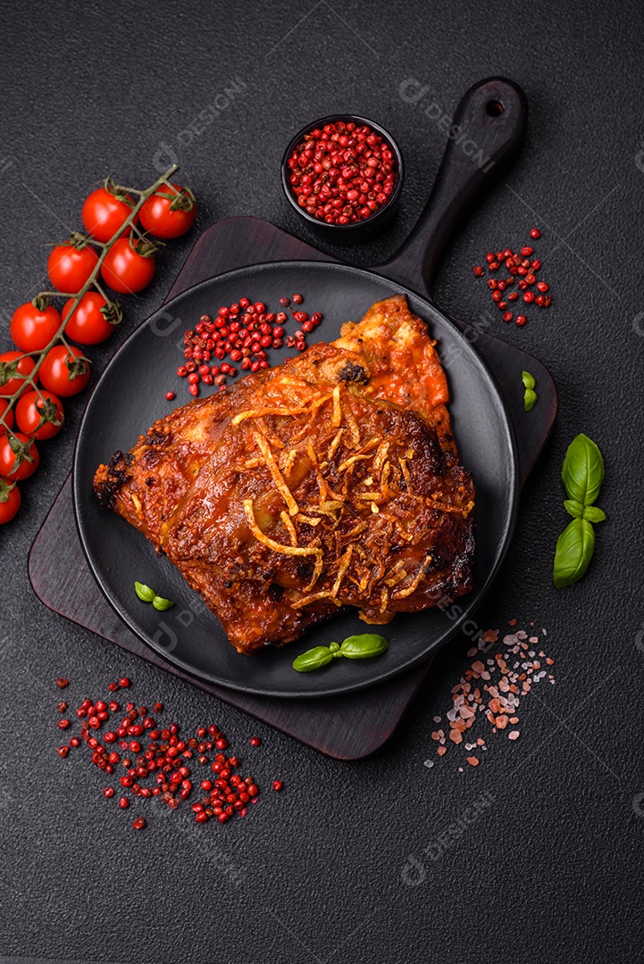 Deliciosas costelas de porco ou de vaca assadas na grelha com sal, especiarias e ervas sobre um fundo escuro de concreto