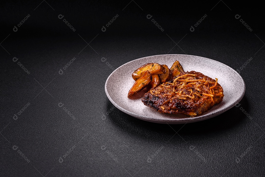 Deliciosas costelas de porco ou de vaca assadas na grelha com sal, especiarias e ervas sobre um fundo escuro de concreto