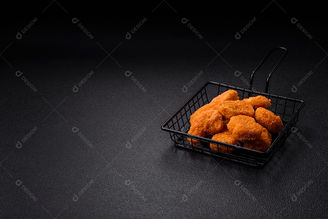 Deliciosos nuggets de frango crocantes frescos em um fundo escuro de concreto. Alimentos não saudáveis, fast food