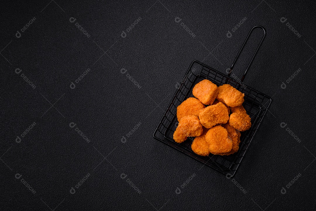 Deliciosos nuggets de frango crocantes frescos em um fundo escuro de concreto. Alimentos não saudáveis, fast food