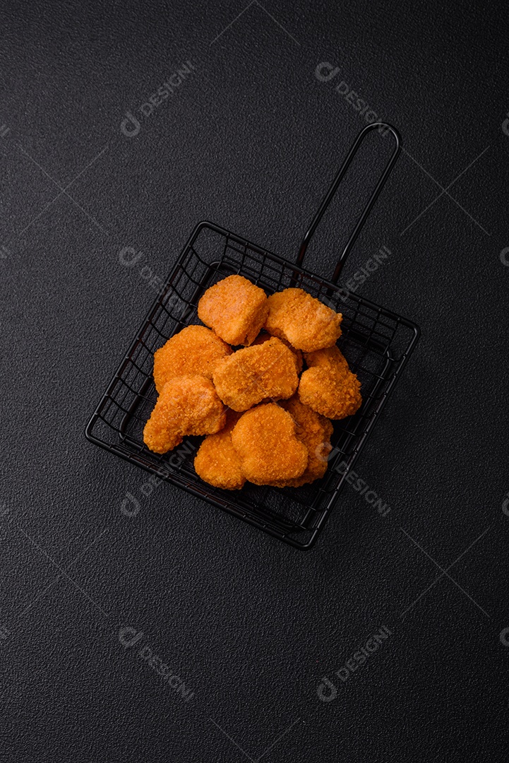 Deliciosos nuggets de frango crocantes frescos em um fundo escuro de concreto. Alimentos não saudáveis, fast food