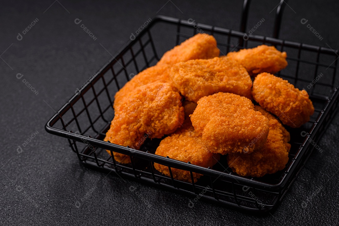 Deliciosos nuggets de frango crocantes frescos em um fundo escuro de concreto. Alimentos não saudáveis, fast food