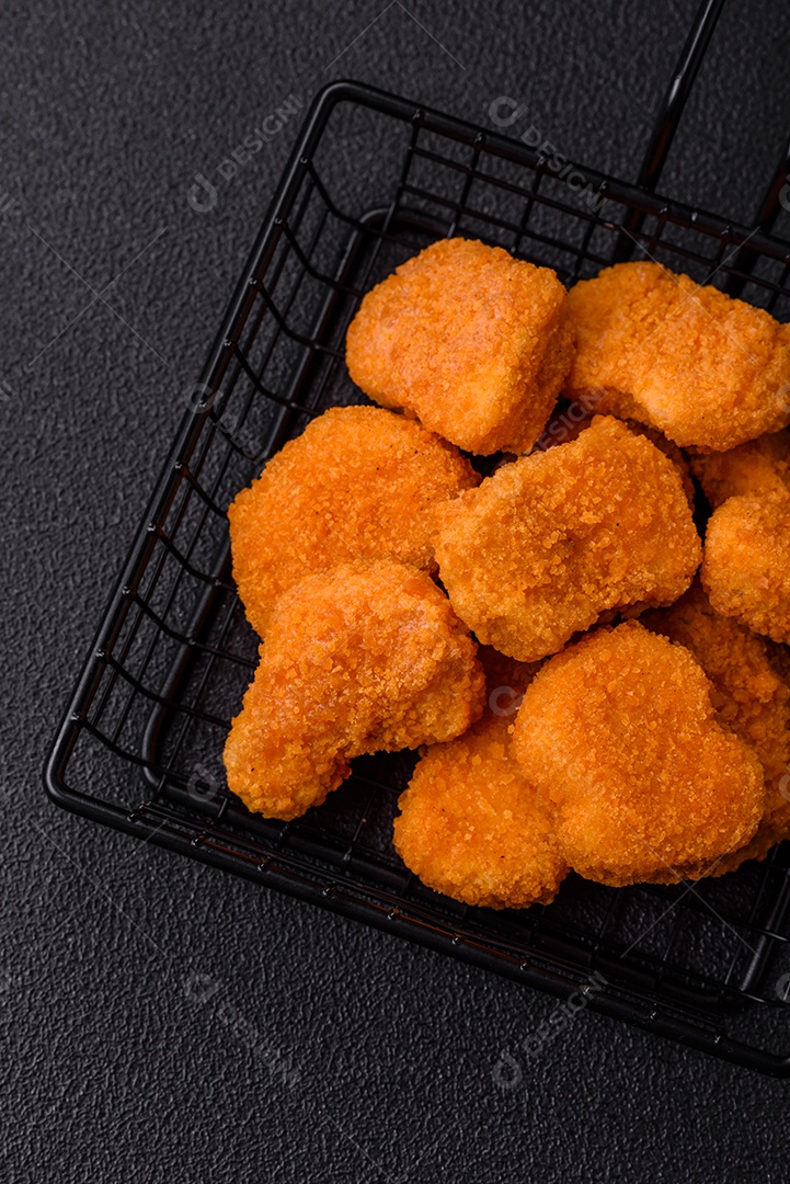 Deliciosos nuggets de frango crocantes frescos em um fundo escuro de concreto. Alimentos não saudáveis, fast food