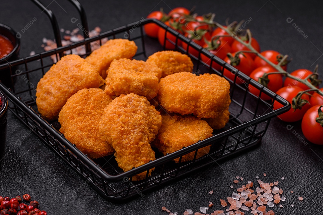 Deliciosos nuggets de frango crocantes frescos em um fundo escuro de concreto. Alimentos não saudáveis, fast food