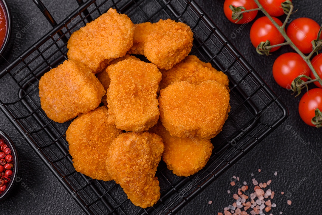 Deliciosos nuggets de frango crocantes frescos em um fundo escuro de concreto. Alimentos não saudáveis, fast food