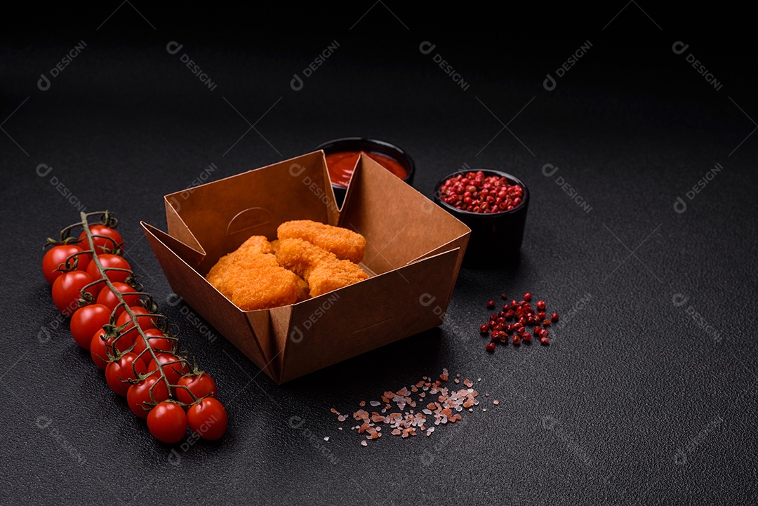 Deliciosos nuggets de frango crocantes frescos em um fundo escuro de concreto. Alimentos não saudáveis, fast food
