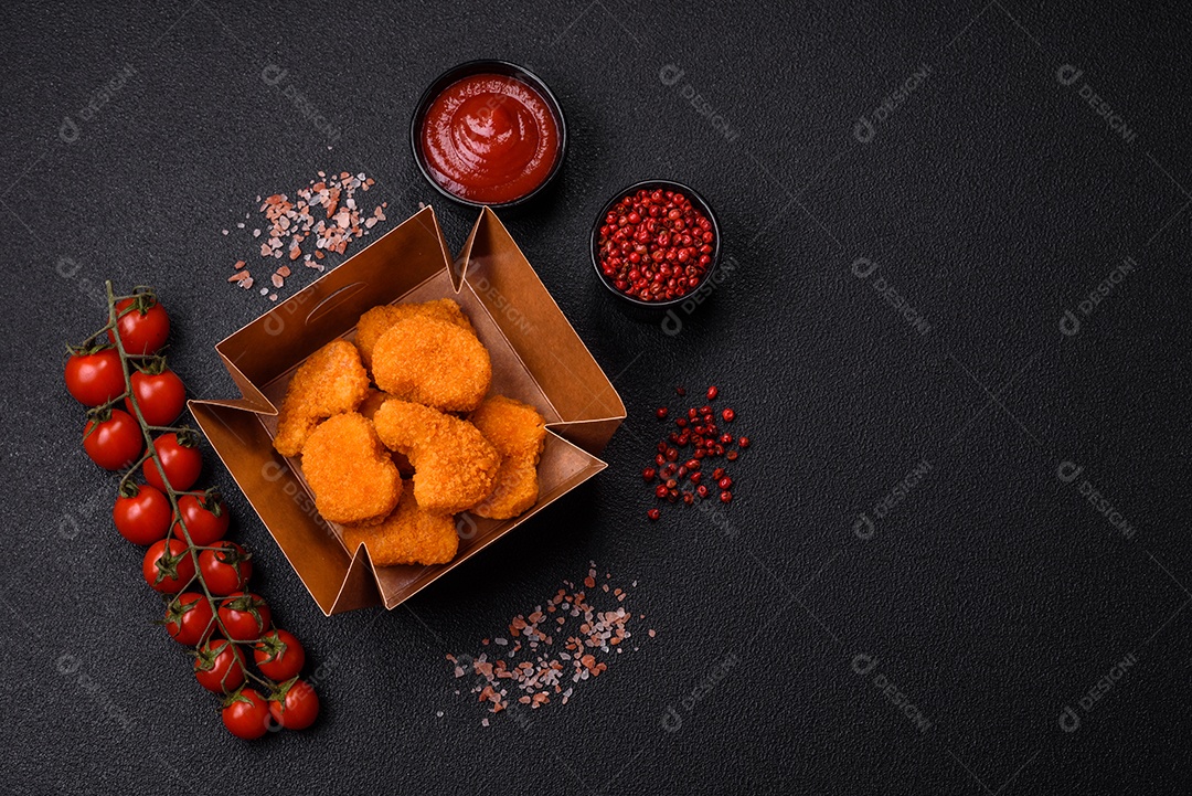 Deliciosos nuggets de frango crocantes frescos em um fundo escuro de concreto. Alimentos não saudáveis, fast food