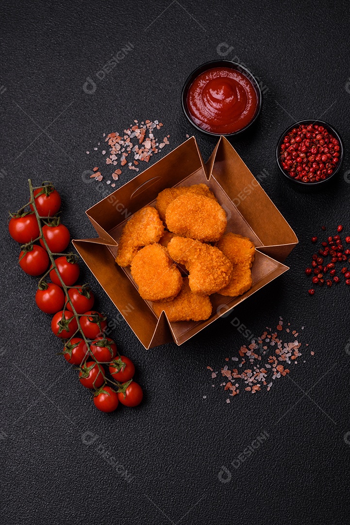 Deliciosos nuggets de frango crocantes frescos em um fundo escuro de concreto. Alimentos não saudáveis, fast food