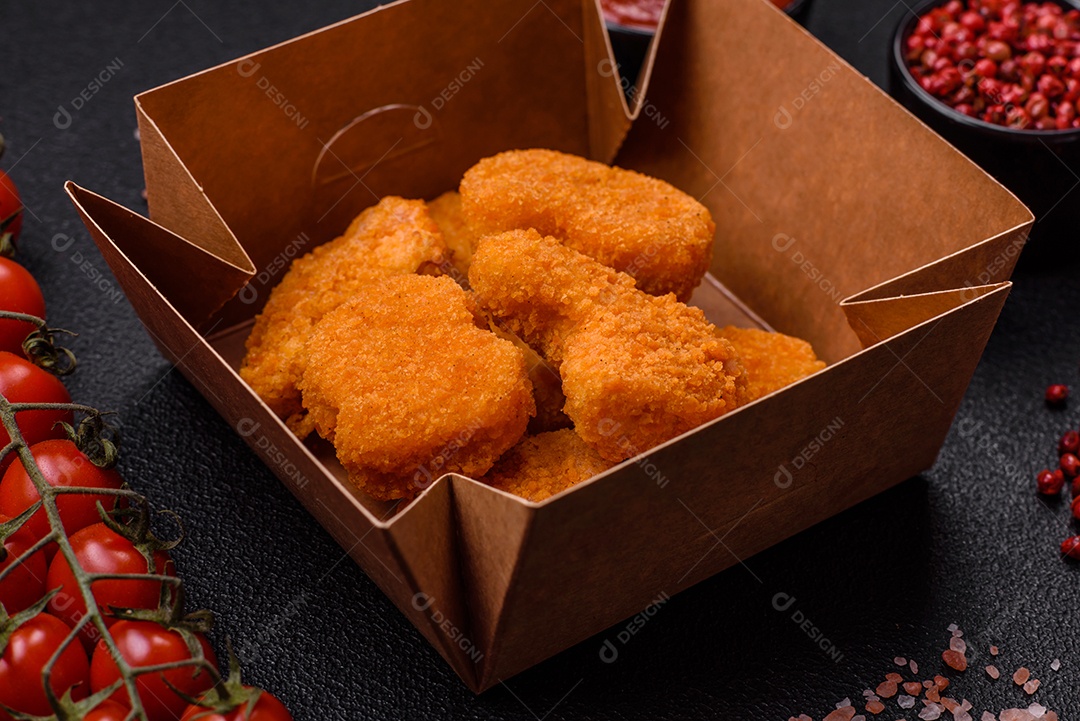 Deliciosos nuggets de frango crocantes frescos em um fundo escuro de concreto. Alimentos não saudáveis, fast food