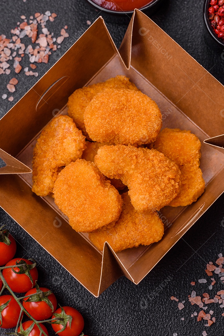 Deliciosos nuggets de frango crocantes frescos em um fundo escuro de concreto. Alimentos não saudáveis, fast food