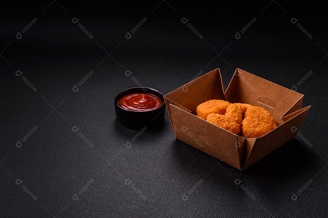 Deliciosos nuggets de frango crocantes frescos em um fundo escuro de concreto. Alimentos não saudáveis, fast food