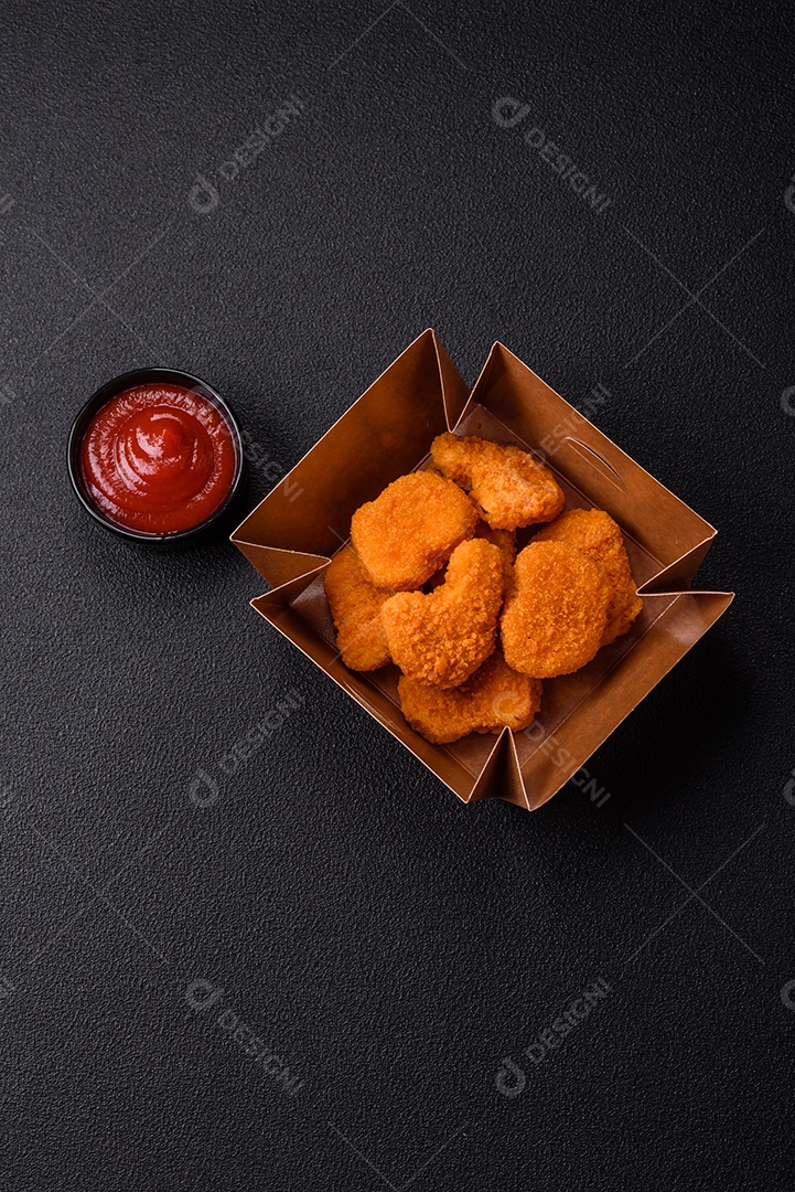 Deliciosos nuggets de frango crocantes frescos em um fundo escuro de concreto. Alimentos não saudáveis, fast food