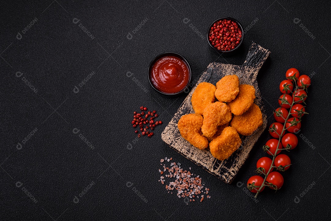 Deliciosos nuggets de frango crocantes frescos em um fundo escuro de concreto. Alimentos não saudáveis, fast food
