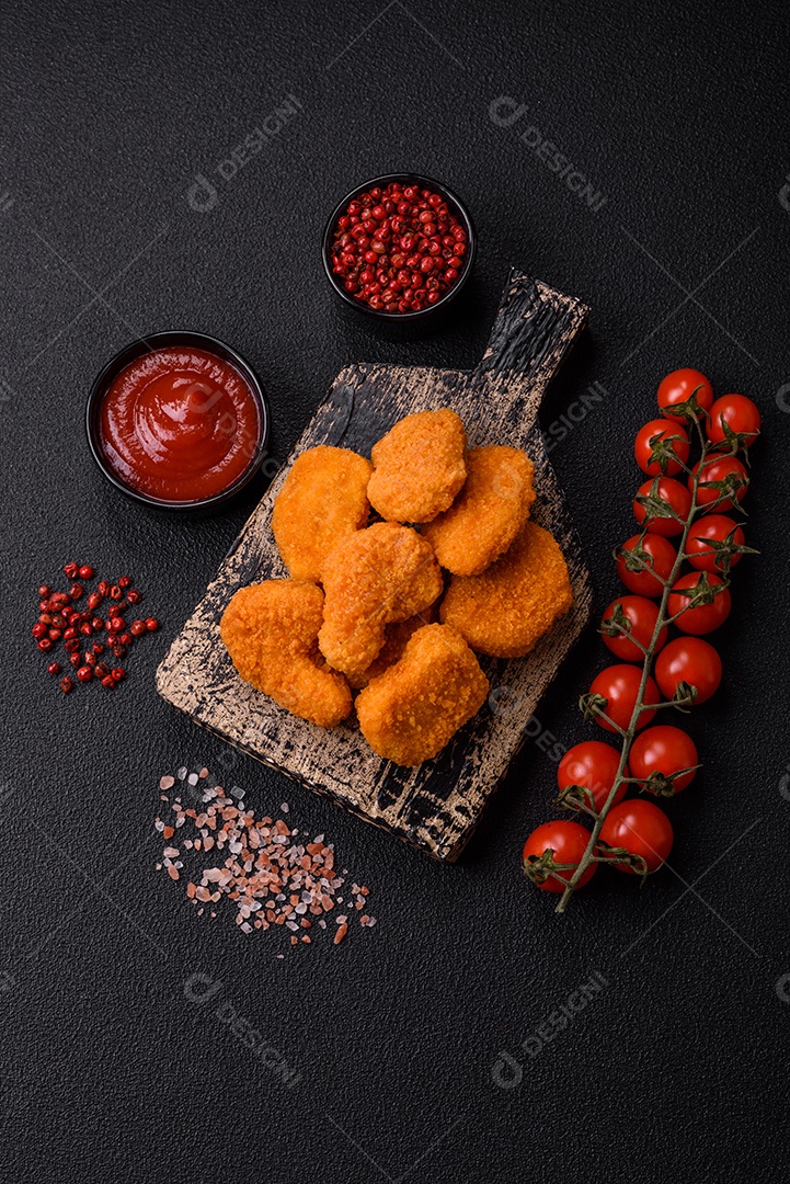 Deliciosos nuggets de frango crocantes frescos em um fundo escuro de concreto. Alimentos não saudáveis, fast food