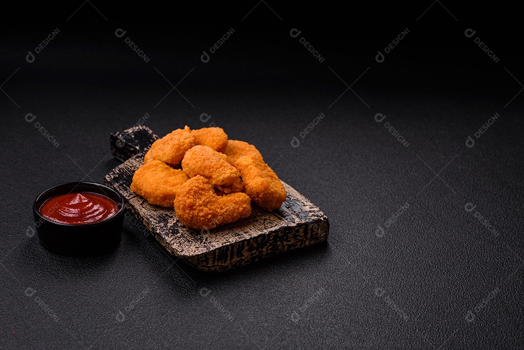 Deliciosos nuggets de frango crocantes frescos em um fundo escuro de concreto. Alimentos não saudáveis, fast food