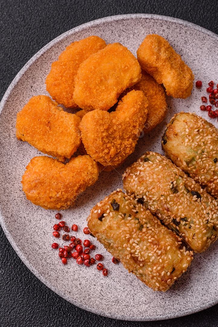 Delicioso prato vegetariano ou vegano em forma de costeletas ou hambúrgueres consistindo de batatas, cenouras, cebolas e feijões em um fundo escuro de concreto