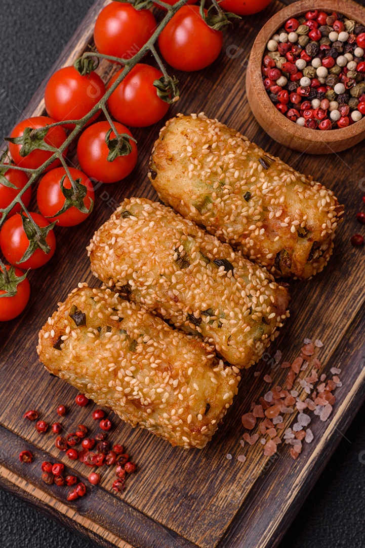 Delicioso prato vegetariano ou vegano em forma de costeletas ou hambúrgueres consistindo de batatas, cenouras, cebolas e feijões em um fundo escuro de concreto