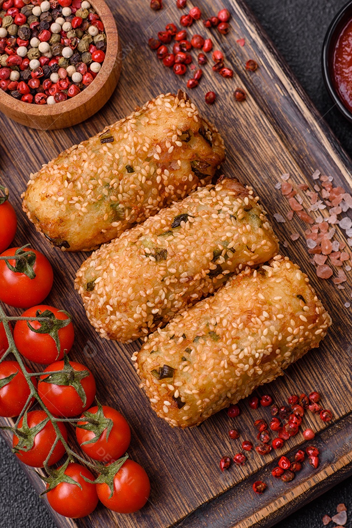 Delicioso prato vegetariano ou vegano em forma de costeletas ou hambúrgueres consistindo de batatas, cenouras, cebolas e feijões em um fundo escuro de concreto