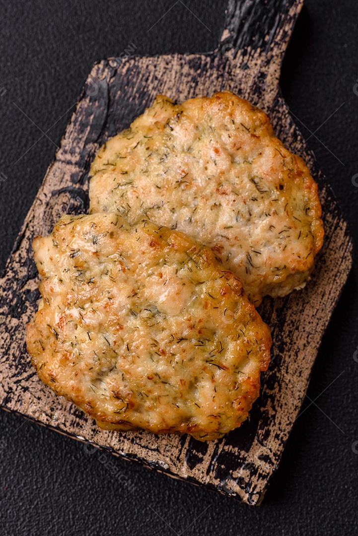 Deliciosas costeletas de frango picado frito com sal, especiarias e ervas sobre um fundo escuro de concreto