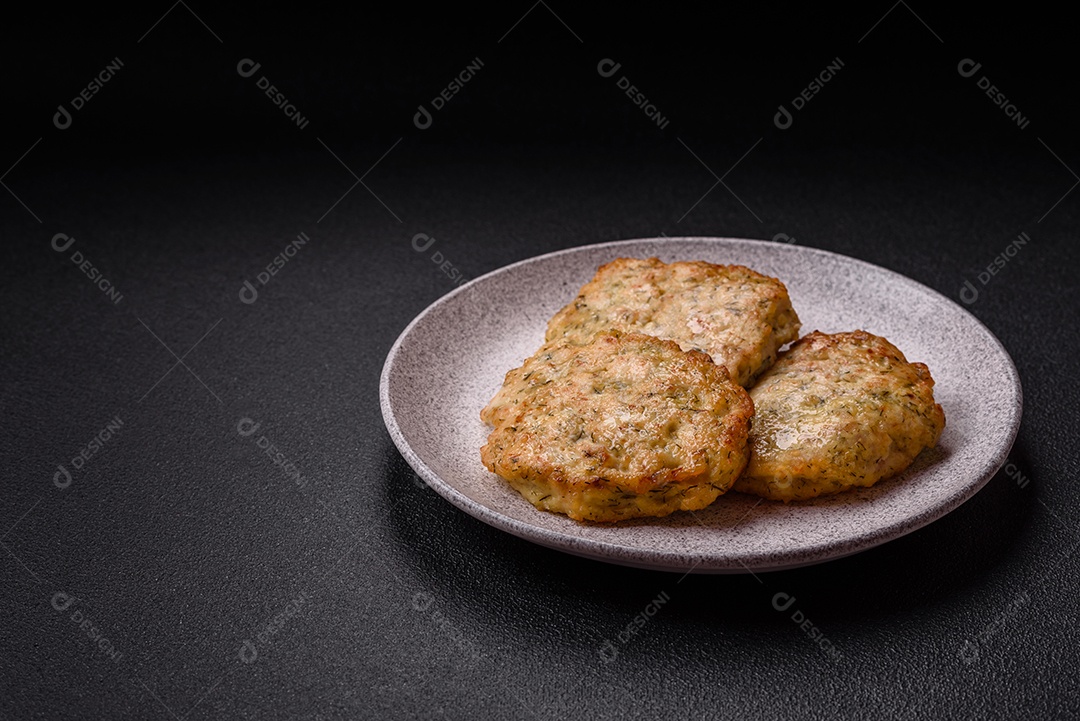 Deliciosas costeletas de frango picado frito com sal, especiarias e ervas sobre um fundo escuro de concreto