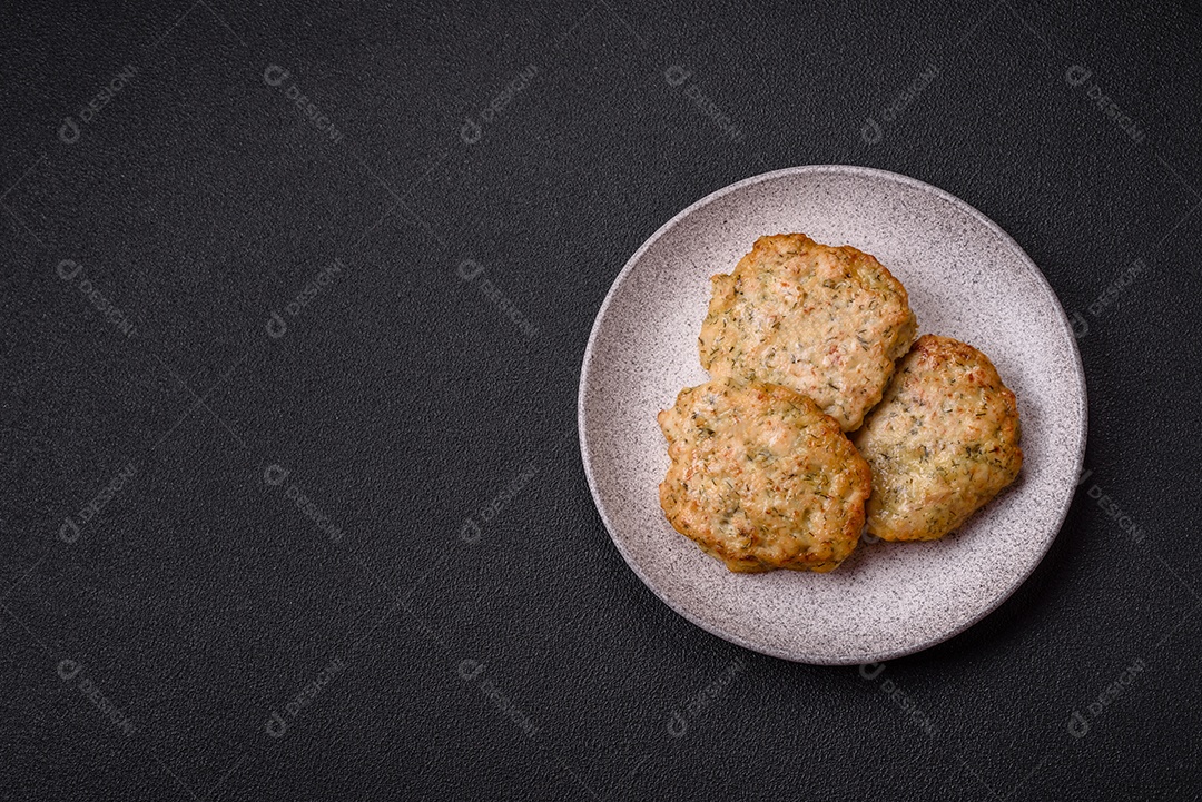 Deliciosas costeletas de frango picado frito com sal, especiarias e ervas sobre um fundo escuro de concreto