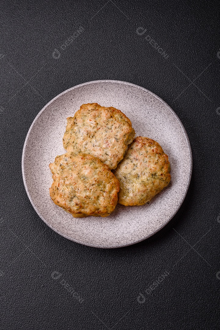 Deliciosas costeletas de frango picado frito com sal, especiarias e ervas sobre um fundo escuro de concreto